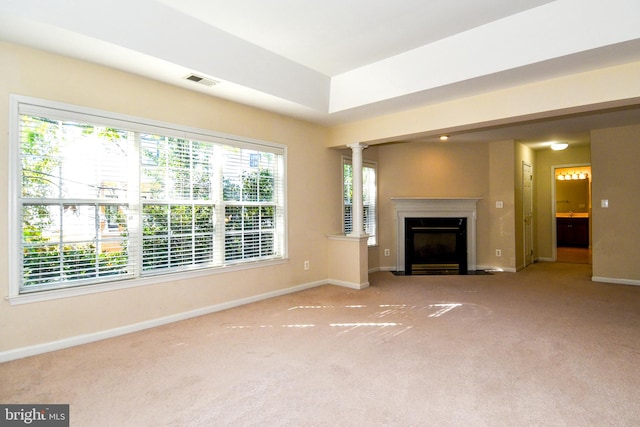 unfurnished living room with ornate columns and carpet