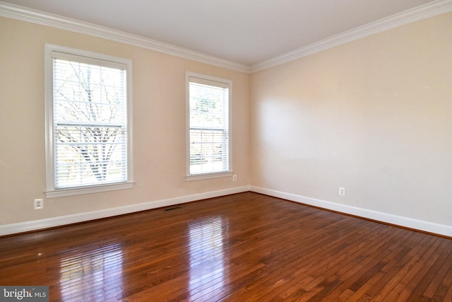 empty room with ornamental molding, a wealth of natural light, and dark hardwood / wood-style flooring