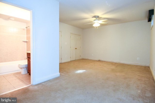 interior space featuring light carpet and ceiling fan