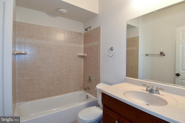 full bathroom featuring vanity, tiled shower / bath combo, and toilet