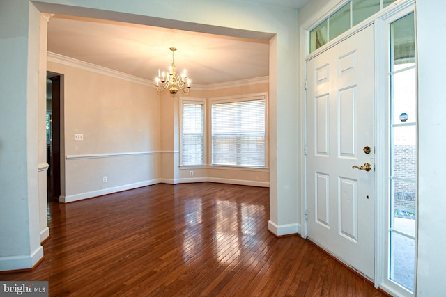 entrance foyer featuring crown molding, a chandelier, and dark wood-type flooring