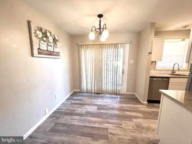 unfurnished dining area with dark hardwood / wood-style floors, sink, and a chandelier