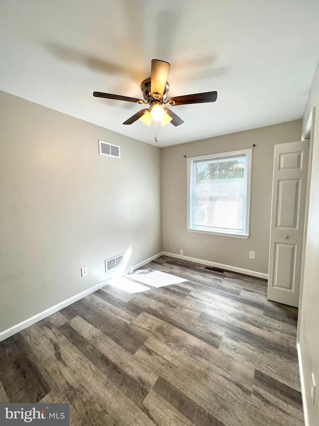 empty room featuring ceiling fan and dark hardwood / wood-style floors