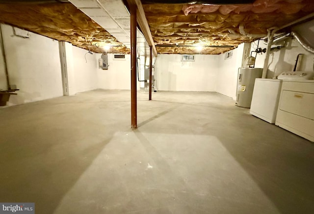 basement featuring washing machine and dryer, electric water heater, and electric panel