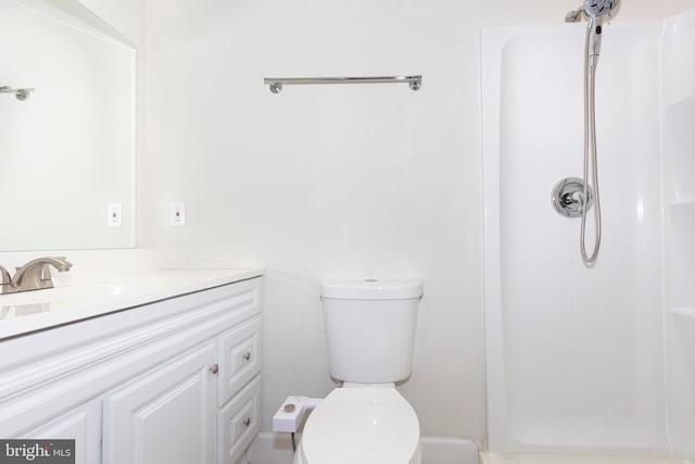 bathroom featuring vanity, toilet, and walk in shower