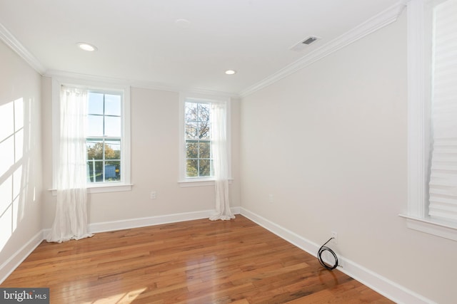 unfurnished room featuring ornamental molding and hardwood / wood-style flooring