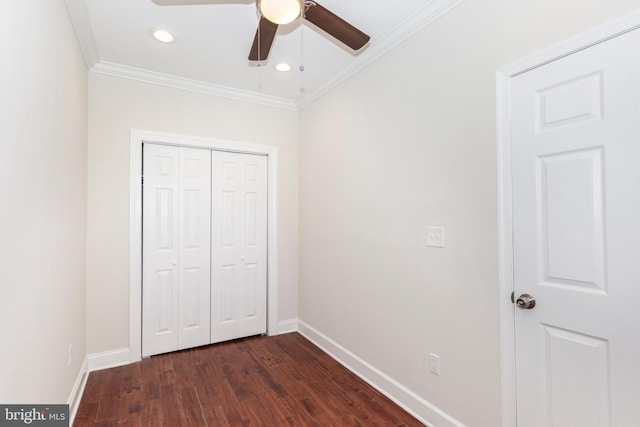 unfurnished bedroom with ornamental molding, a closet, dark hardwood / wood-style floors, and ceiling fan