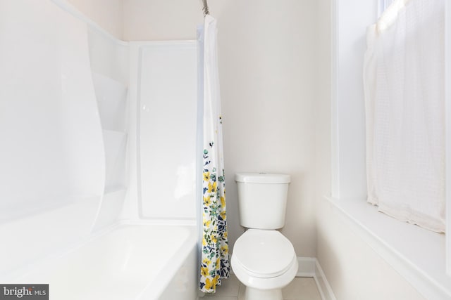 bathroom featuring toilet, tile patterned floors, and shower / bath combo