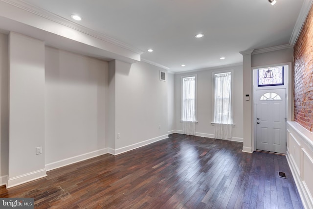 foyer entrance featuring ornamental molding, brick wall, and dark hardwood / wood-style flooring