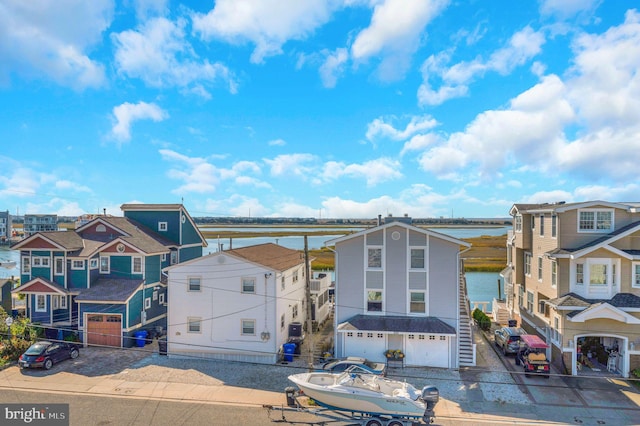 694 21st St, Avalon, NJ 08202 - view of front of property featuring driveway, a water view, a residential view, and a garage