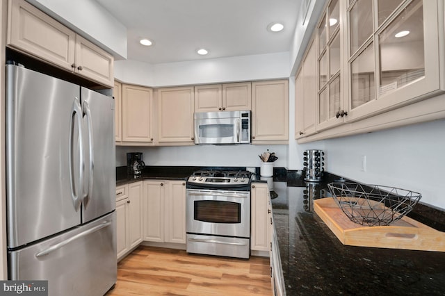 694 21st St, Avalon, NJ 08202 - kitchen featuring dark stone counters, glass insert cabinets, appliances with stainless steel finishes, light wood-type flooring, and recessed lighting
