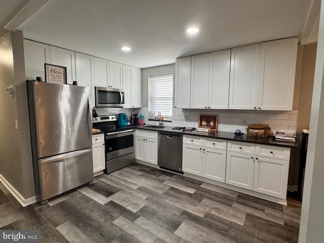 kitchen featuring white cabinetry, appliances with stainless steel finishes, dark wood-type flooring, and sink