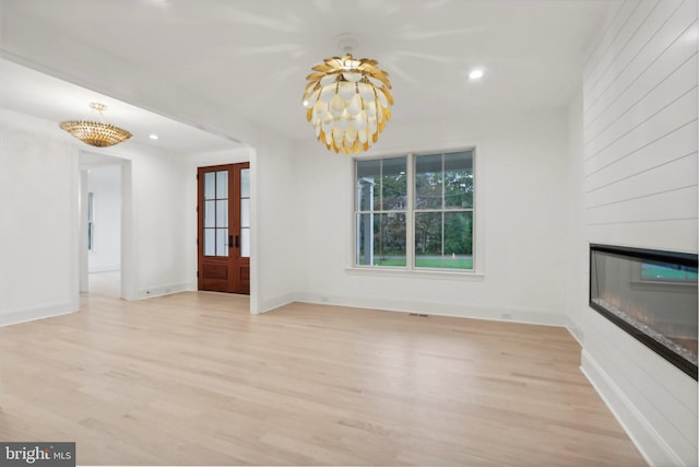 interior space with french doors, light wood-type flooring, and a fireplace