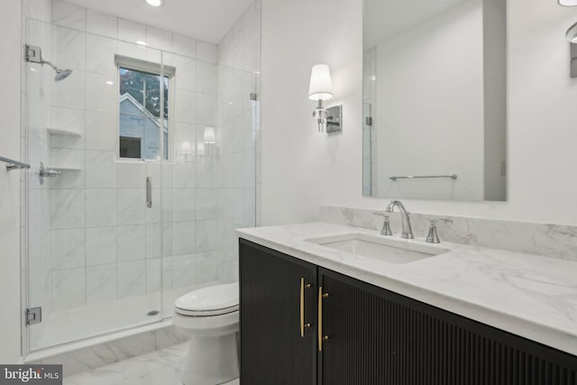 bathroom featuring vanity, toilet, and a shower with door