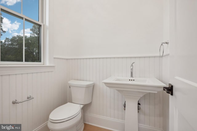 bathroom featuring toilet and wooden walls