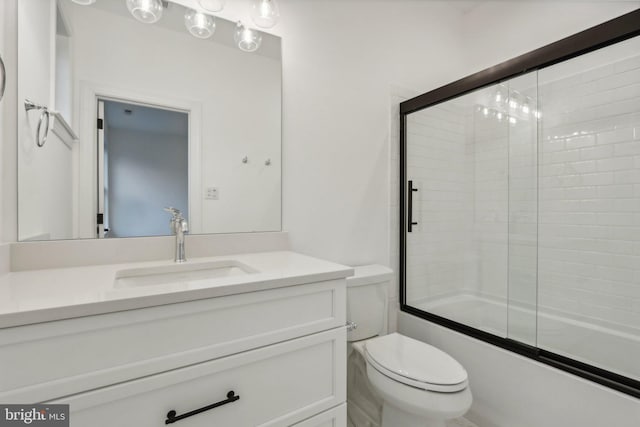 full bathroom with vanity, toilet, and shower / bath combination with glass door