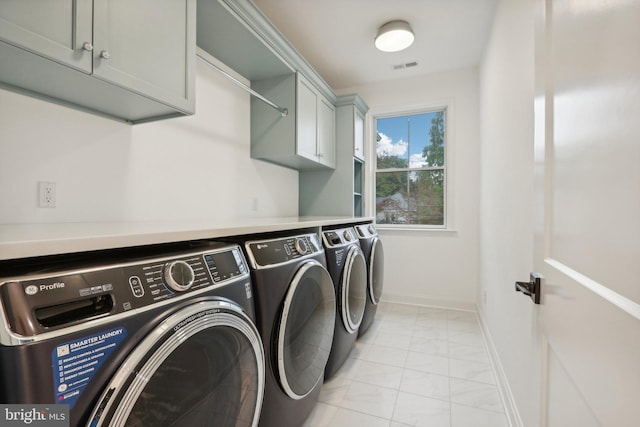 laundry room featuring cabinets and washing machine and clothes dryer