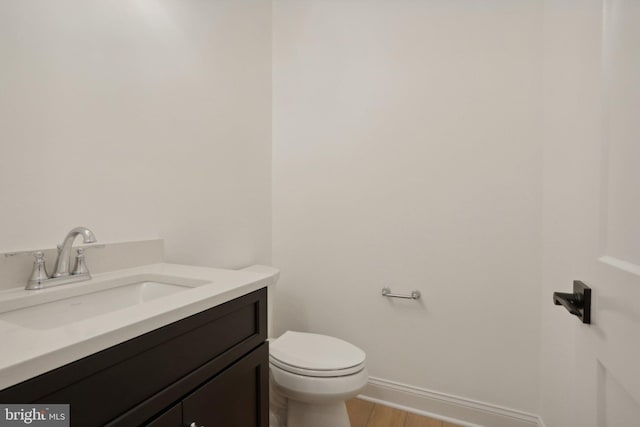 bathroom featuring vanity, hardwood / wood-style flooring, and toilet