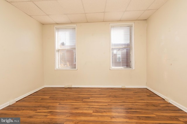 unfurnished room featuring hardwood / wood-style floors and a paneled ceiling