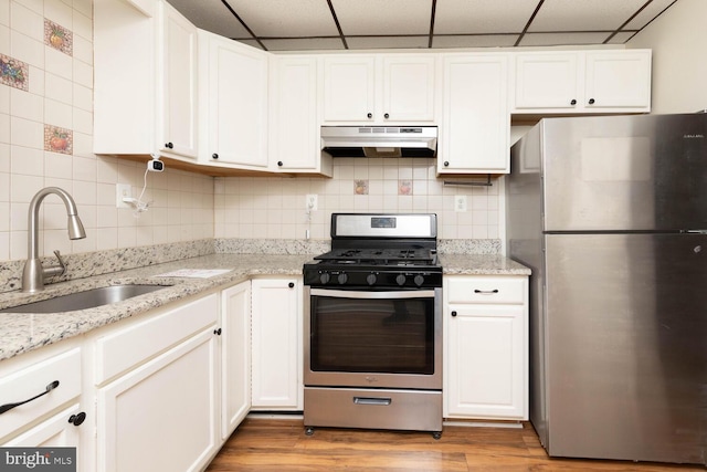 kitchen with a paneled ceiling, appliances with stainless steel finishes, sink, and white cabinets