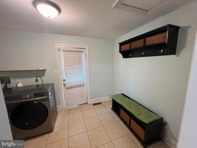 clothes washing area featuring washer / clothes dryer and light tile patterned flooring