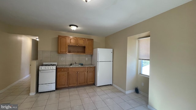 kitchen featuring backsplash, sink, white appliances, and light tile patterned floors