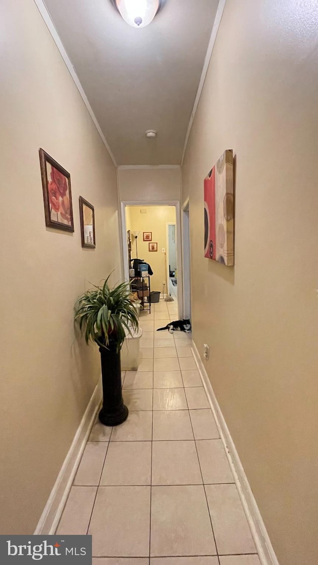 hallway featuring crown molding and light tile patterned floors