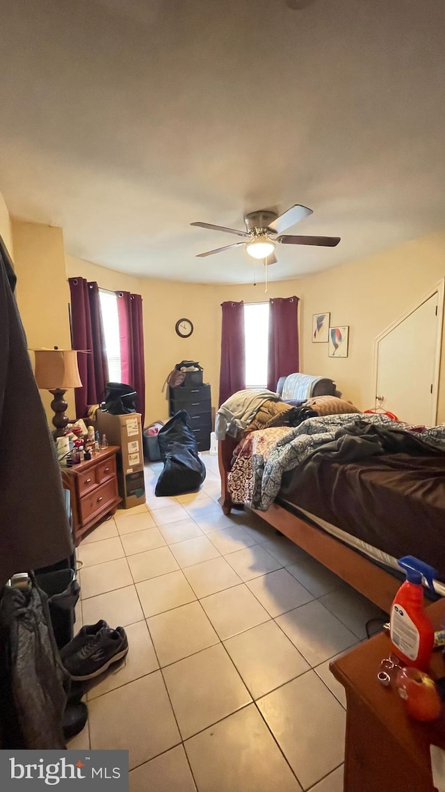 tiled bedroom featuring ceiling fan