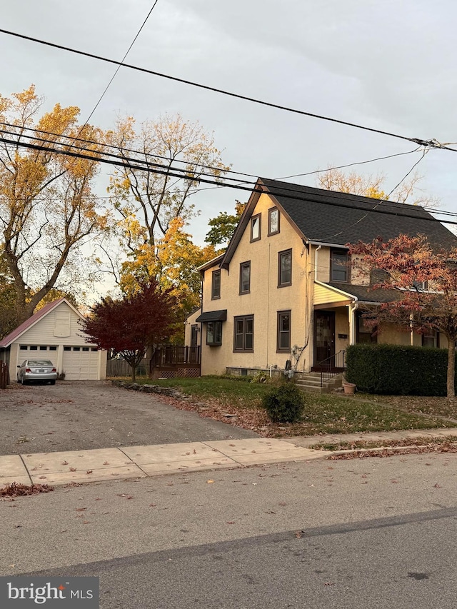 view of front of home featuring a garage and an outbuilding