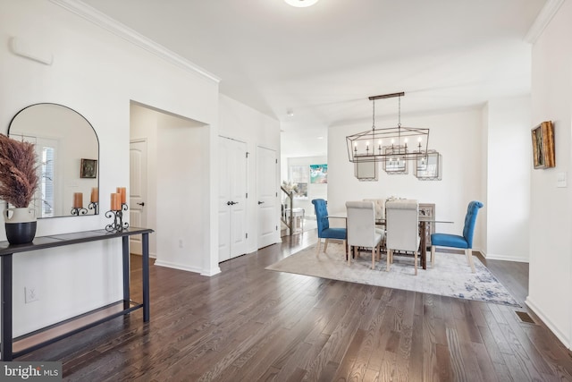 dining area with dark hardwood / wood-style flooring and crown molding