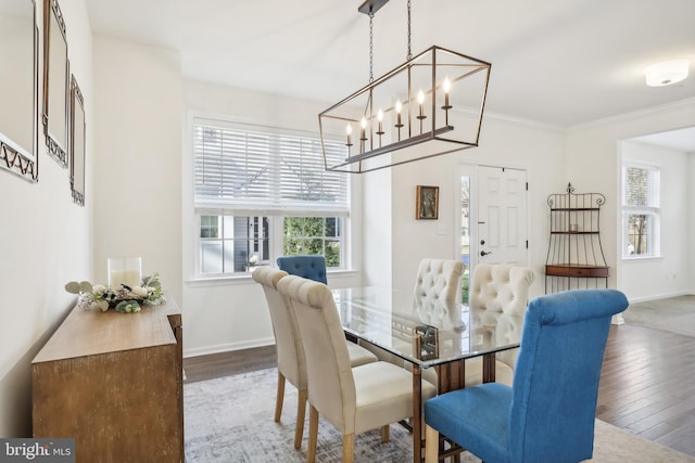 dining space featuring ornamental molding, a notable chandelier, and dark hardwood / wood-style floors