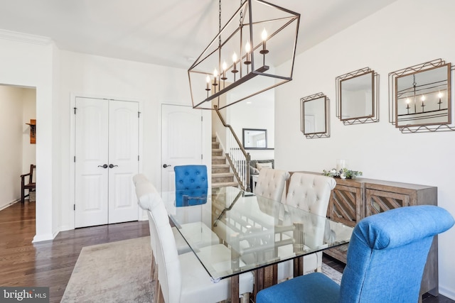 dining area featuring dark wood-type flooring and crown molding