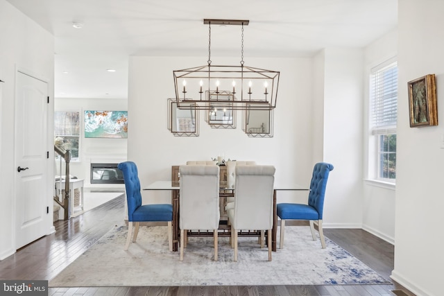 dining space with a wealth of natural light, a notable chandelier, and dark hardwood / wood-style floors