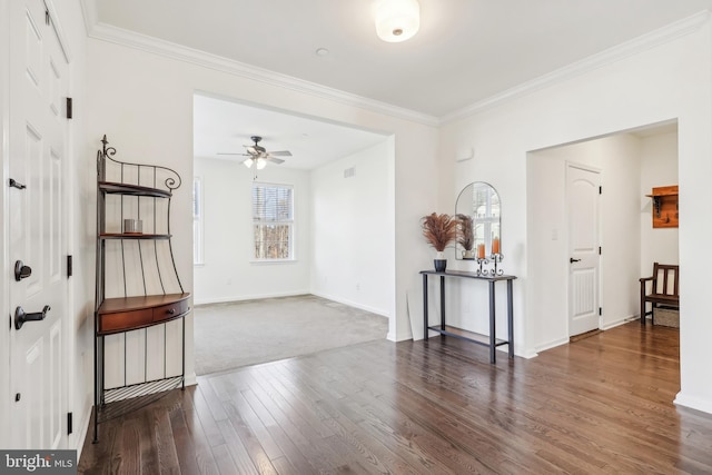 unfurnished room with ceiling fan, dark carpet, and ornamental molding