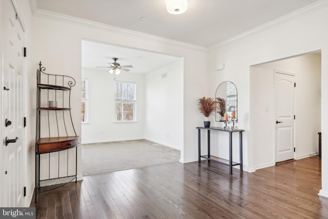 entryway with dark colored carpet, ceiling fan, and crown molding