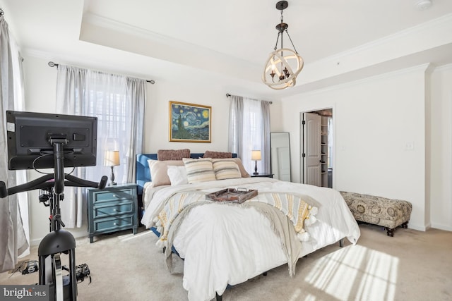 carpeted bedroom featuring a chandelier, a tray ceiling, and ornamental molding