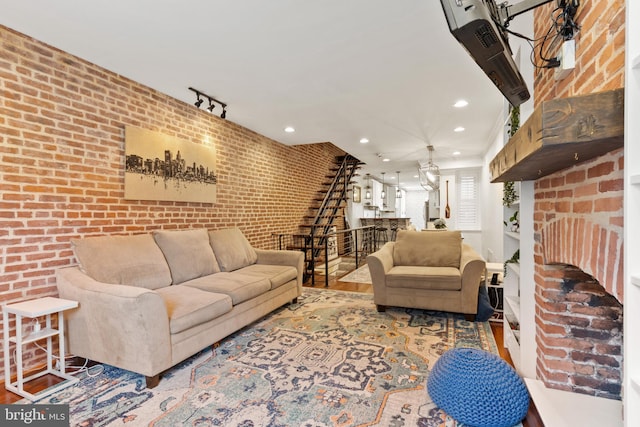 living room with brick wall and hardwood / wood-style flooring