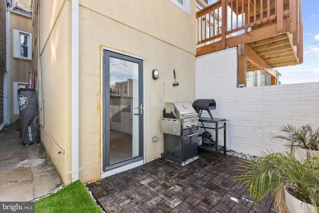 entrance to property with a wooden deck and a patio