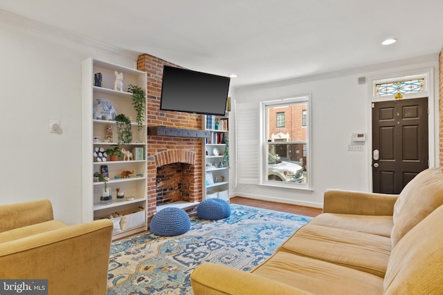 living room with hardwood / wood-style flooring, crown molding, and a fireplace