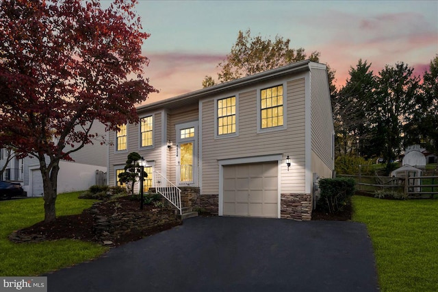 split foyer home featuring a yard and a garage