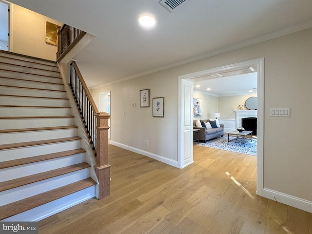 stairway featuring ornamental molding and hardwood / wood-style floors