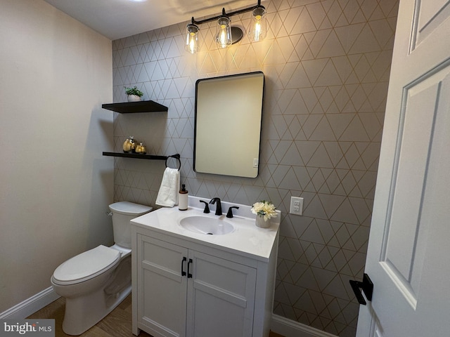 bathroom with vanity, toilet, and tile walls