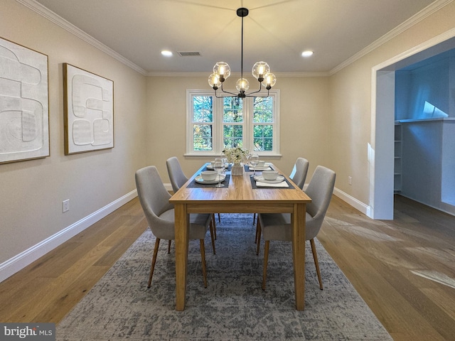 dining space with ornamental molding, dark wood-type flooring, and an inviting chandelier