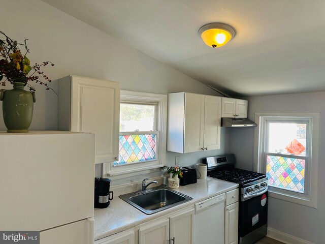 kitchen featuring white cabinets, white appliances, vaulted ceiling, and plenty of natural light