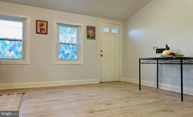 entryway with lofted ceiling and light hardwood / wood-style flooring