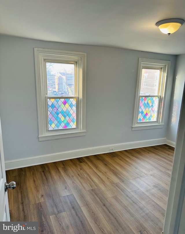 spare room featuring a wealth of natural light and light hardwood / wood-style floors