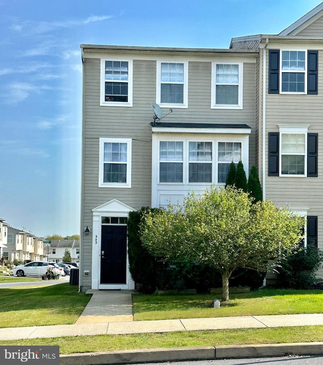 townhome / multi-family property with a front lawn