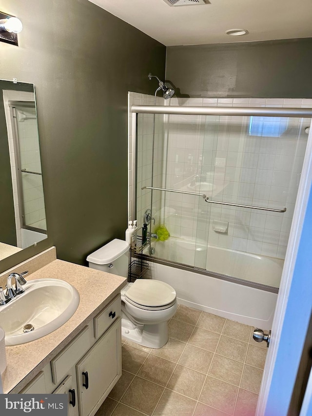 full bathroom with vanity, toilet, tile patterned floors, and bath / shower combo with glass door