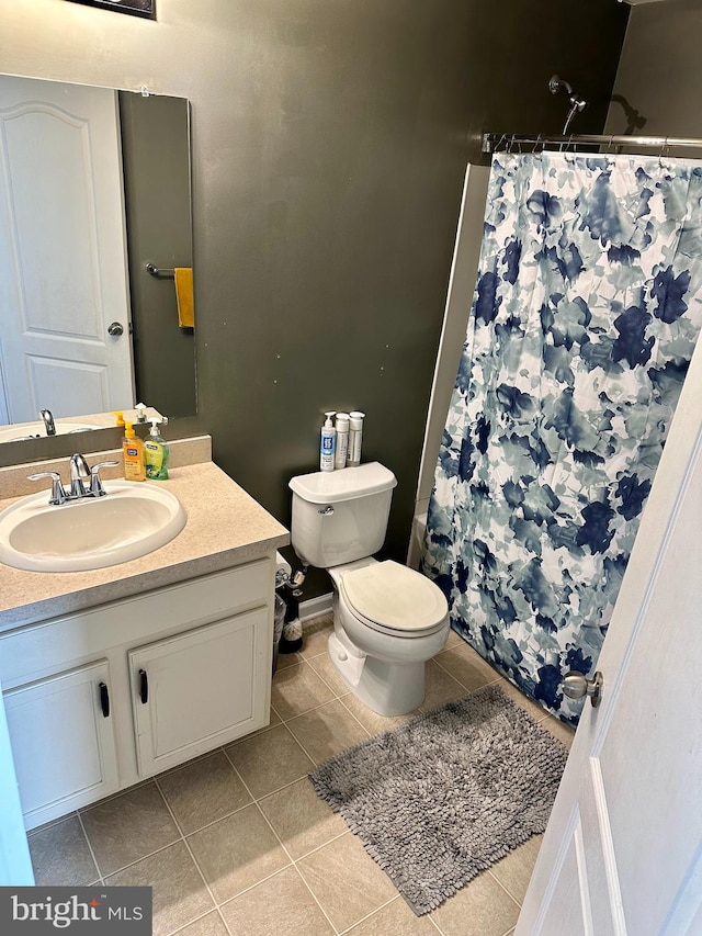 bathroom with toilet, walk in shower, vanity, and tile patterned floors