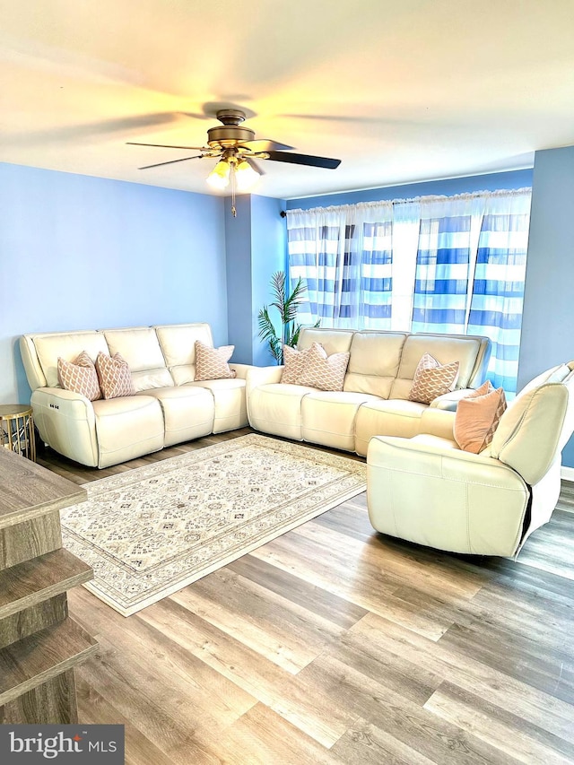 living room featuring ceiling fan and hardwood / wood-style flooring